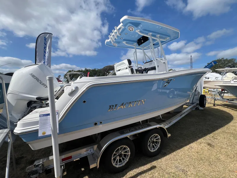 Slide: The Image of 2025 Blackfin 222 CC boat on trailer under blue sky. - 2