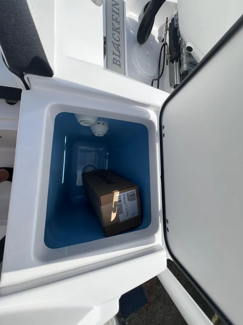 Slide: The Image of 2025 Blackfin 222 CC boat storage compartment with a package inside. - 7