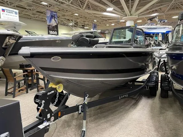 Slide: The Image of 2025 Lund 1975 Tyee Sport boat displayed indoors on a trailer. - 2