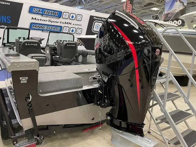 Slide: The Image of 2025 Lund 1975 Tyee Sport boat with powerful outboard motor at a showroom display. - 8