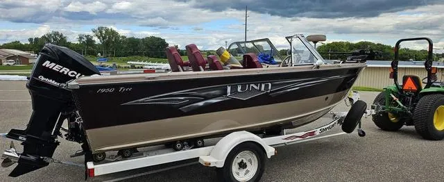 Slide: The Image of 1996 Lund 1950 Tyee boat on trailer, parked outdoors, with a Mercury outboard motor. - 3