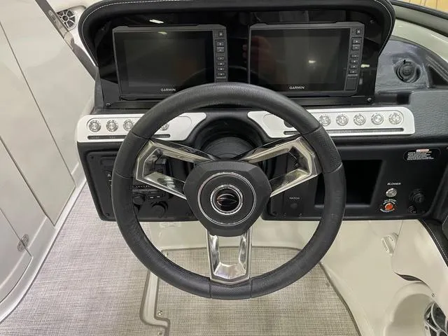 Slide: The Image of 2023 Crownline 260 SS boat dashboard with dual Garmin displays and steering wheel. - 3