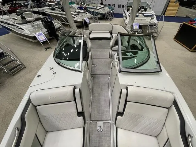 Slide: The Image of 2023 Crownline 260 SS boat interior with white seating and sleek design at a showroom. - 5