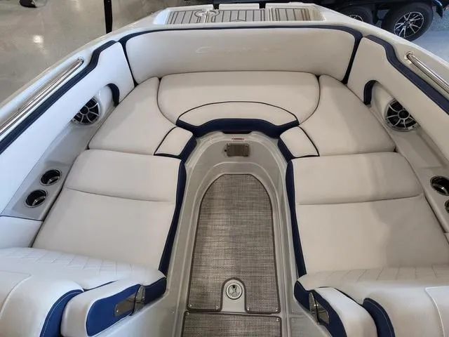Slide: The Image of 2024 Crownline E260 XS boat interior with white and blue seating, cup holders, and speakers. - 10