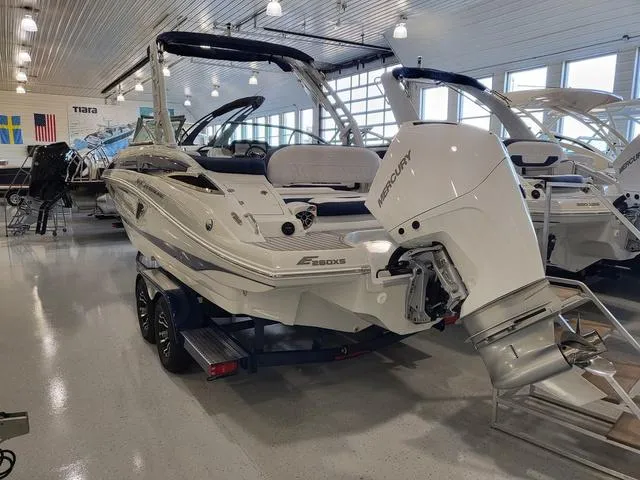 Slide: The Image of 2024 Crownline E260 XS boat with Mercury engine in showroom setting. - 3