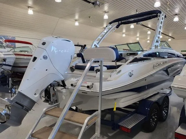 Slide: The Image of 2024 Crownline E260 XS boat with outboard motor in showroom. - 4