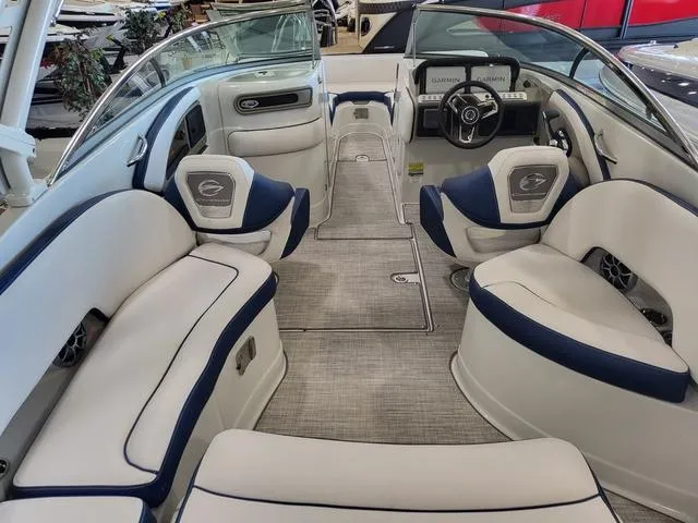 Slide: The Image of 2024 Crownline E260 XS boat interior with plush seating and modern dashboard. - 7