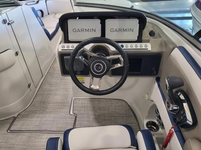 Slide: The Image of 2024 Crownline E260 XS boat cockpit with dual Garmin displays and modern steering wheel. - 8