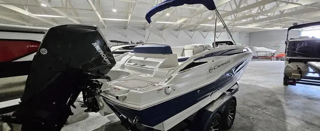 Slide: The Image of 2024 Crownline E230 XS boat with Mercury outboard in a showroom. - 4