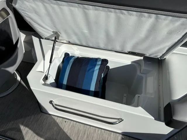 Slide: The Image of Open storage compartment in a 2021 Cobalt R8 boat with a striped cushion inside. - 9