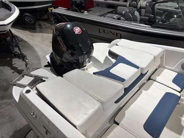 Slide: The Image of 2021 Tahoe 450 TF boat with Mercury outboard motor, white and blue seating, in showroom. - 7