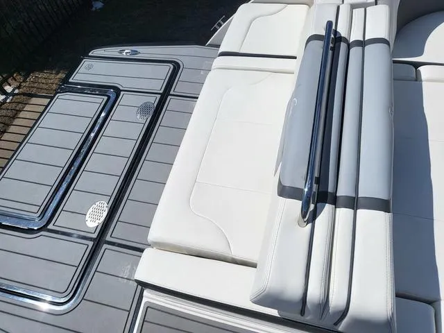 Slide: The Image of 2022 Chaparral 28 Surf boat deck with sleek white seating and gray flooring. - 17