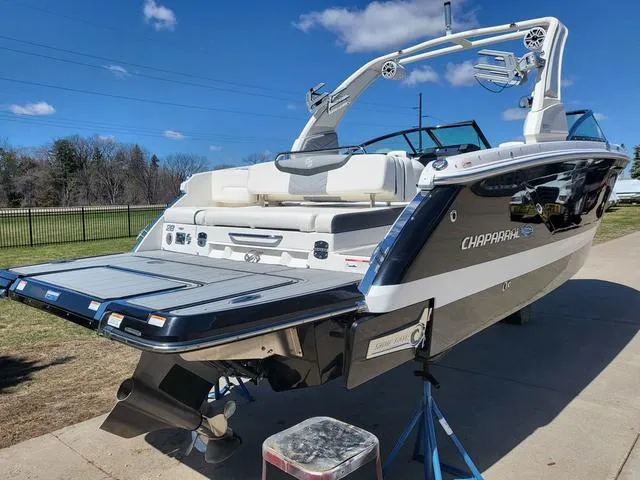 Slide: The Image of 2022 Chaparral 28 Surf boat with sleek design, parked on a sunny day. - 4