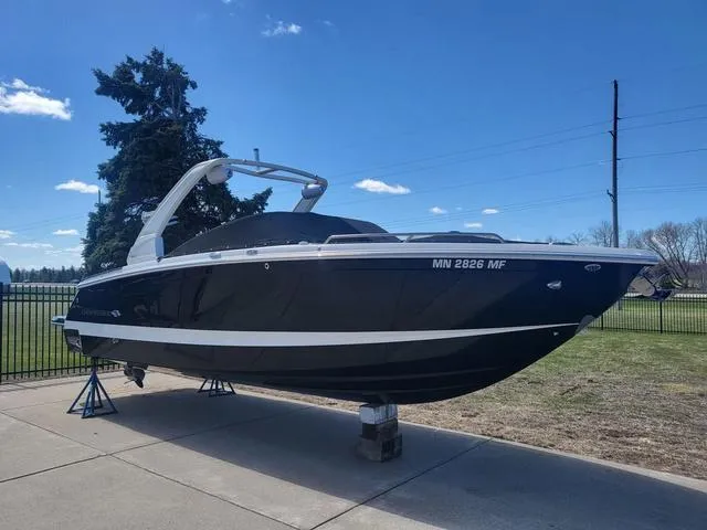 Slide: The Image of 2022 Chaparral 28 Surf boat displayed outdoors on a sunny day. - 5