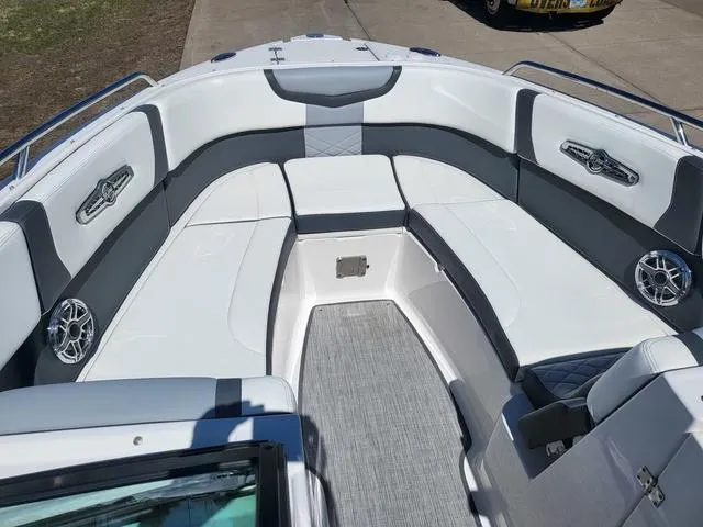 Slide: The Image of 2022 Chaparral 28 Surf boat interior with white and gray seating, stainless steel accents. - 9
