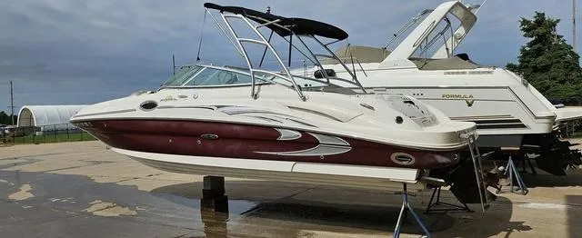 Slide: The Image of 2006 Sea Ray 270 Sundeck boat on stands, with a sleek maroon and white design. - 10
