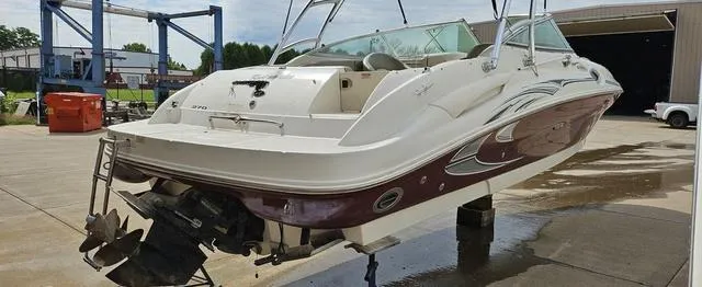 Slide: The Image of 2006 Sea Ray 270 Sundeck boat on a lift, showcasing rear view and outboard motor. - 11