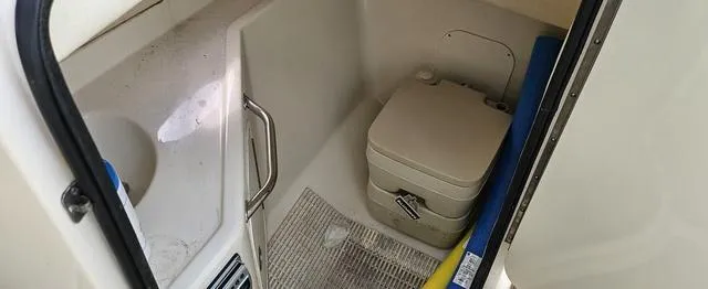 Slide: The Image of 2006 Sea Ray 270 Sundeck interior with portable toilet and storage area. - 6