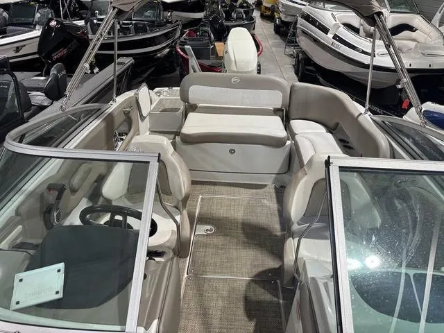 Slide: The Image of 2019 Crownline E 215 XS boat interior with seating and steering wheel in showroom. - 13