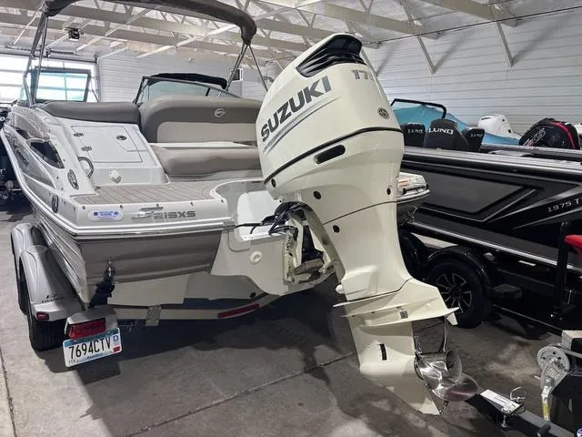 Slide: The Image of 2019 Crownline E 215 XS boat with Suzuki outboard motor in a showroom. - 3
