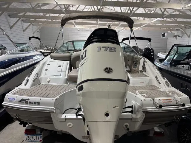 Slide: The Image of 2019 Crownline E 215 XS boat in showroom, featuring outboard motor and spacious deck. - 4