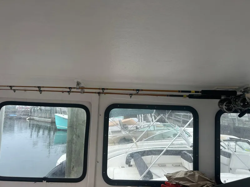 Slide: The Image of Interior view of a 1998 Northern Bay Pilothouse 36 with fishing rods and marina backdrop. - 14