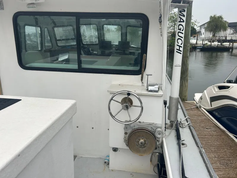 Slide: The Image of 1998 Northern Bay Pilothouse 36 boat with steering wheel and dock view. - 17