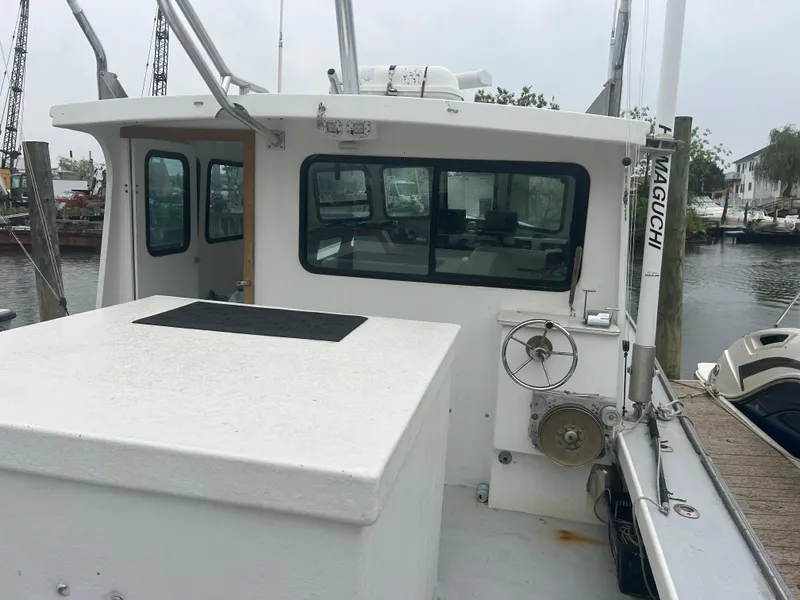 Slide: The Image of 1998 Northern Bay Pilothouse 36 boat docked, featuring a spacious deck and pilothouse. - 2