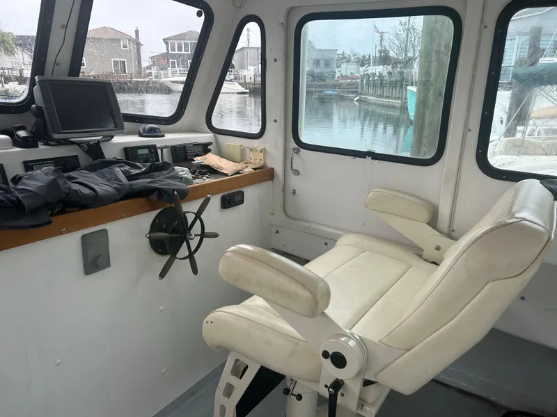 Slide: The Image of Interior of 1998 Northern Bay Pilothouse 36 with helm, chair, and windows overlooking marina. - 6