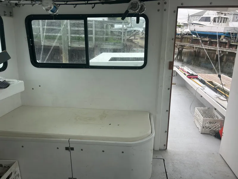Slide: The Image of Interior view of a 1998 Northern Bay Pilothouse 36 boat, showing seating and dockside. - 8
