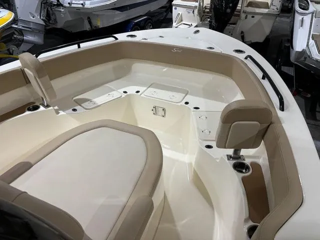 Slide: The Image of 2025 Scout 215 XSF boat interior with beige seating and cup holders. - 10