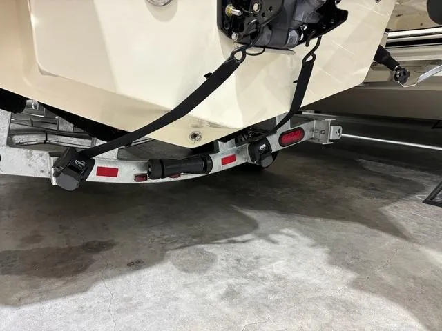 Slide: The Image of 2025 Scout 215 XSF boat secured on a trailer with straps. - 14