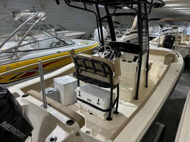 Slide: The Image of 2025 Scout 215 XSF boat interior with seating and steering console in showroom. - 3