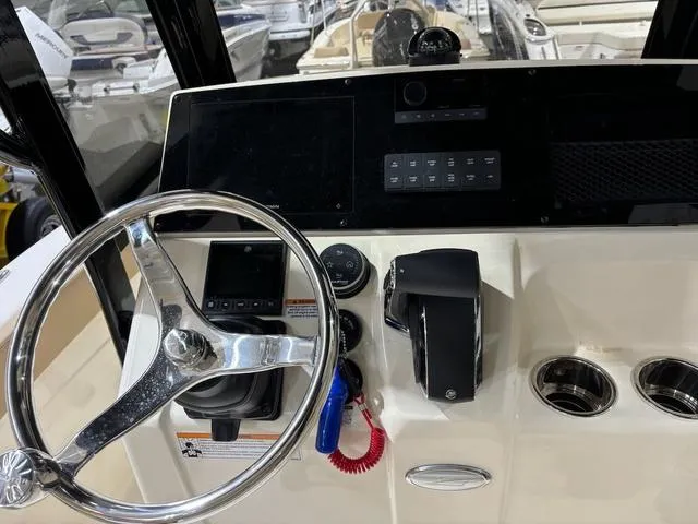 Slide: The Image of 2025 Scout 215 XSF boat dashboard with steering wheel and control panel. - 8