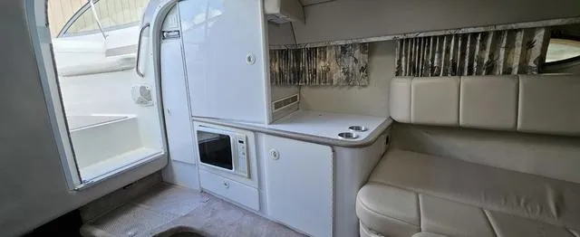 Slide: The Image of 1998 Formula Boats 330 SS interior with kitchenette and seating area. - 11