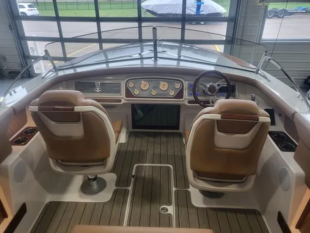 Slide: The Image of 2024 Thoroughbred u23i boat interior with dual seats and modern dashboard in a showroom. - 17