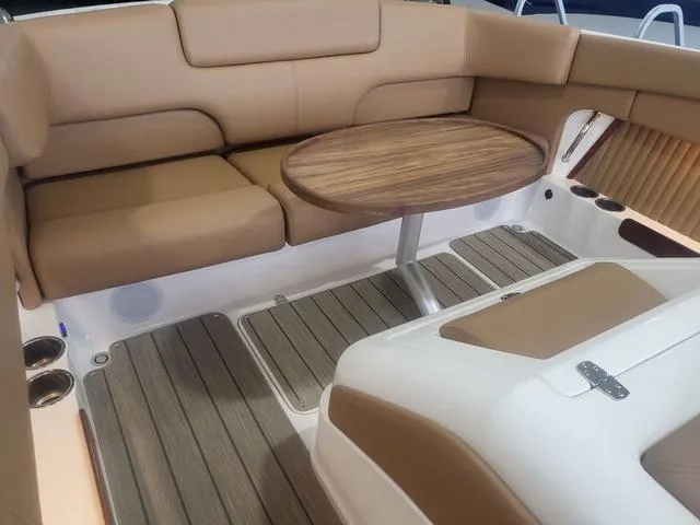 Slide: The Image of Luxurious seating area on 2024 Thoroughbred u23i boat with wooden table and cushioned seats. - 20