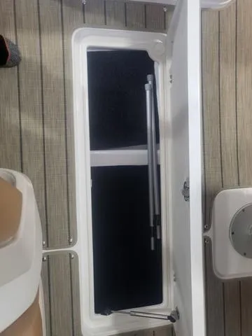 Slide: The Image of Open storage compartment on a 2024 Thoroughbred u23i boat with wooden flooring. - 21