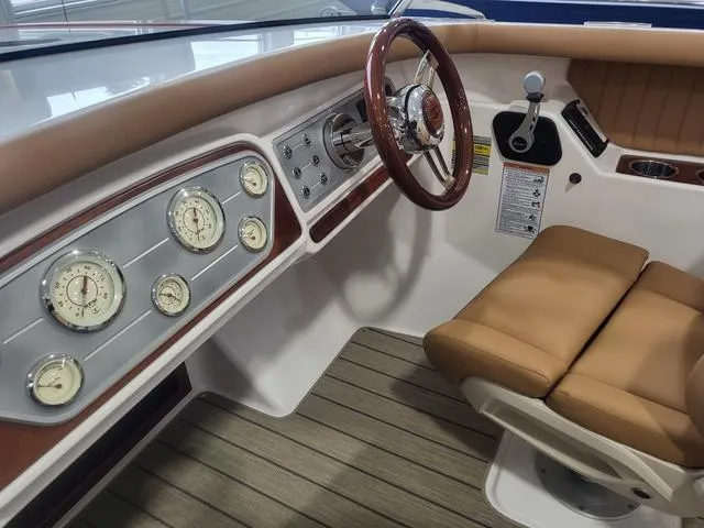 Slide: The Image of Interior of 2024 Thoroughbred u23i boat with classic gauges and tan seating. - 23