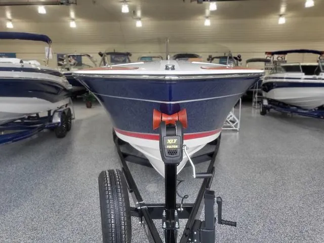 Slide: The Image of 2024 Thoroughbred u23i boat on trailer in showroom, surrounded by other boats. - 27