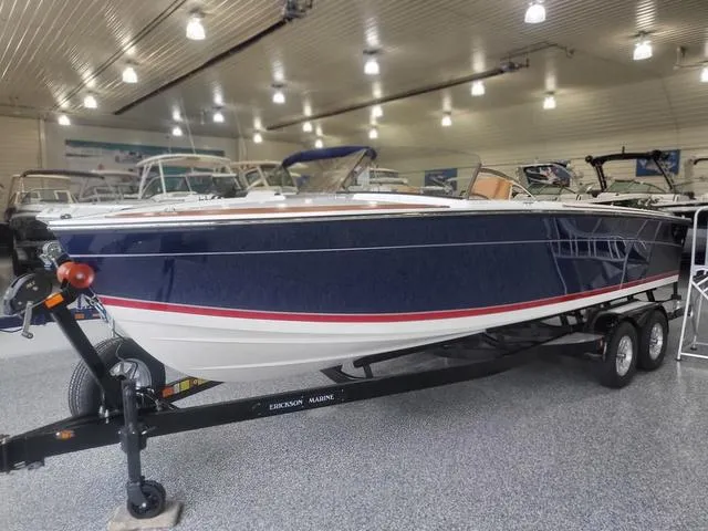 Slide: The Image of 2024 Thoroughbred u23i boat on trailer in showroom, blue and white design. - 29