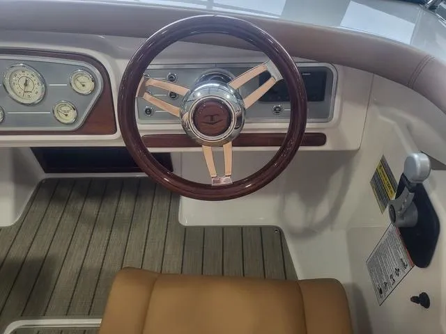 Slide: The Image of Steering wheel and dashboard of 2024 Thoroughbred u23i boat with classic gauges and wood accents. - 7
