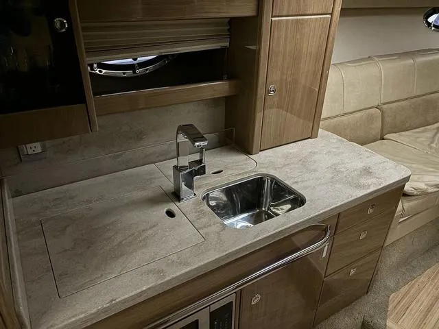 Slide: The Image of 2015 Formula Boats 400 Super Sport interior with modern kitchenette and sink. - 13