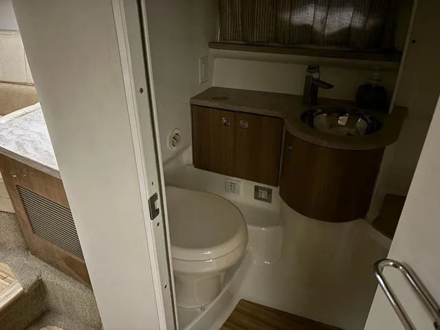 Slide: The Image of 2015 Formula Boats 400 Super Sport bathroom interior with modern fixtures and wood accents. - 17