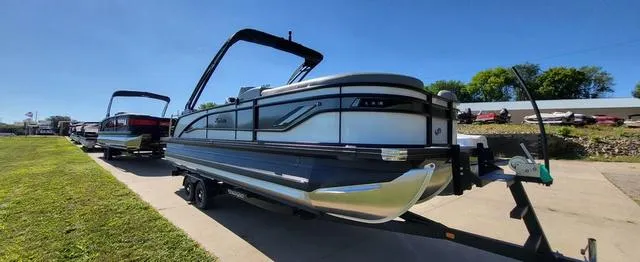 Slide: The Image of 2024 Barletta Corsa 25UEA boat on trailer, parked on grass under clear blue sky. - 3