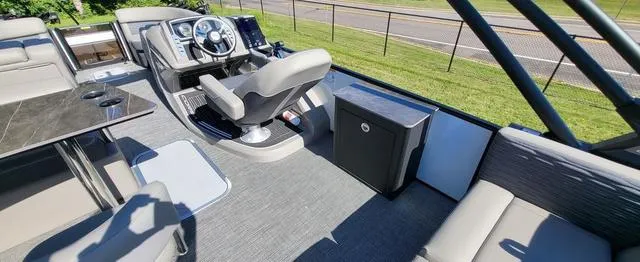 Slide: The Image of 2024 Barletta Corsa 25UEA boat interior with helm, seating, and table on a sunny day. - 8