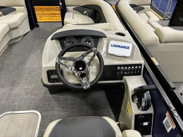 Slide: The Image of 2024 Barletta Aria A22UC boat dashboard with steering wheel and Lowrance display. - 5