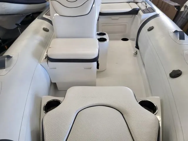 Slide: The Image of 2024 Walker Bay Venture 13 boat interior with white seating and cup holders. - 4