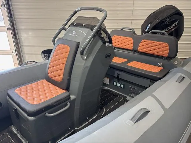 Slide: The Image of 2023 Highfield Sport 390 boat interior with orange quilted seats and Mercury engine. - 3