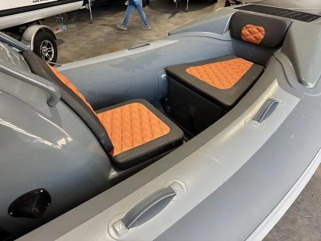 Slide: The Image of 2023 Highfield Sport 390 boat interior with orange quilted seats and gray hull. - 7